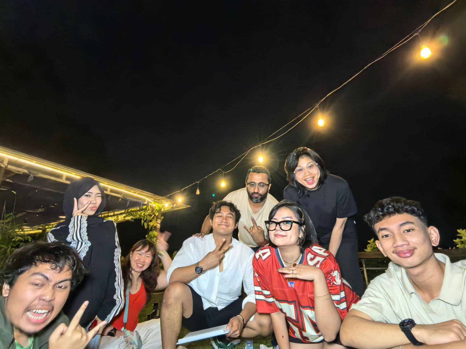 Group photo at night, everyone pulling a face